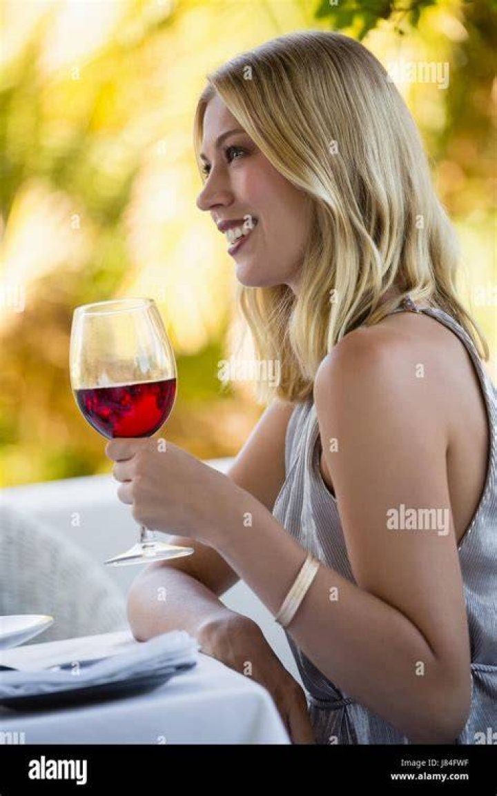 a woman holding a wine glass in her hands